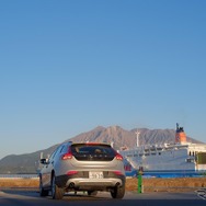 鹿児島高にて桜島をバックに。青と白の大型船は奄美・沖縄航路。