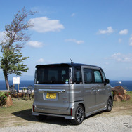 スズキ スペーシアカスタム HYBRID XSターボのリアビュー。鹿児島・錦江湾をバックに。