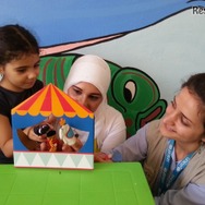 ユニセフ教育専門官とともに、ユニセフのECDキットに含まれている指人形を使って遊ぶ、シリアの女の子（5歳） (c) UNICEF_UNI176330_Youngmeyer