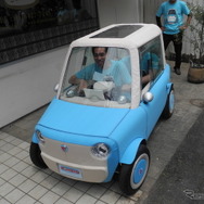 試作した超小型電気自動車に乗り込みハンドルを握る伊藤慎介社長