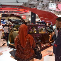 【インドネシアオートショー16】今日からが本番、品定めをする来場者＆価格表を持ったスタッフ 画像